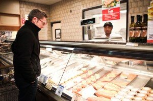 Erie Community College professor Steven Gjurich leans over the seafood counter